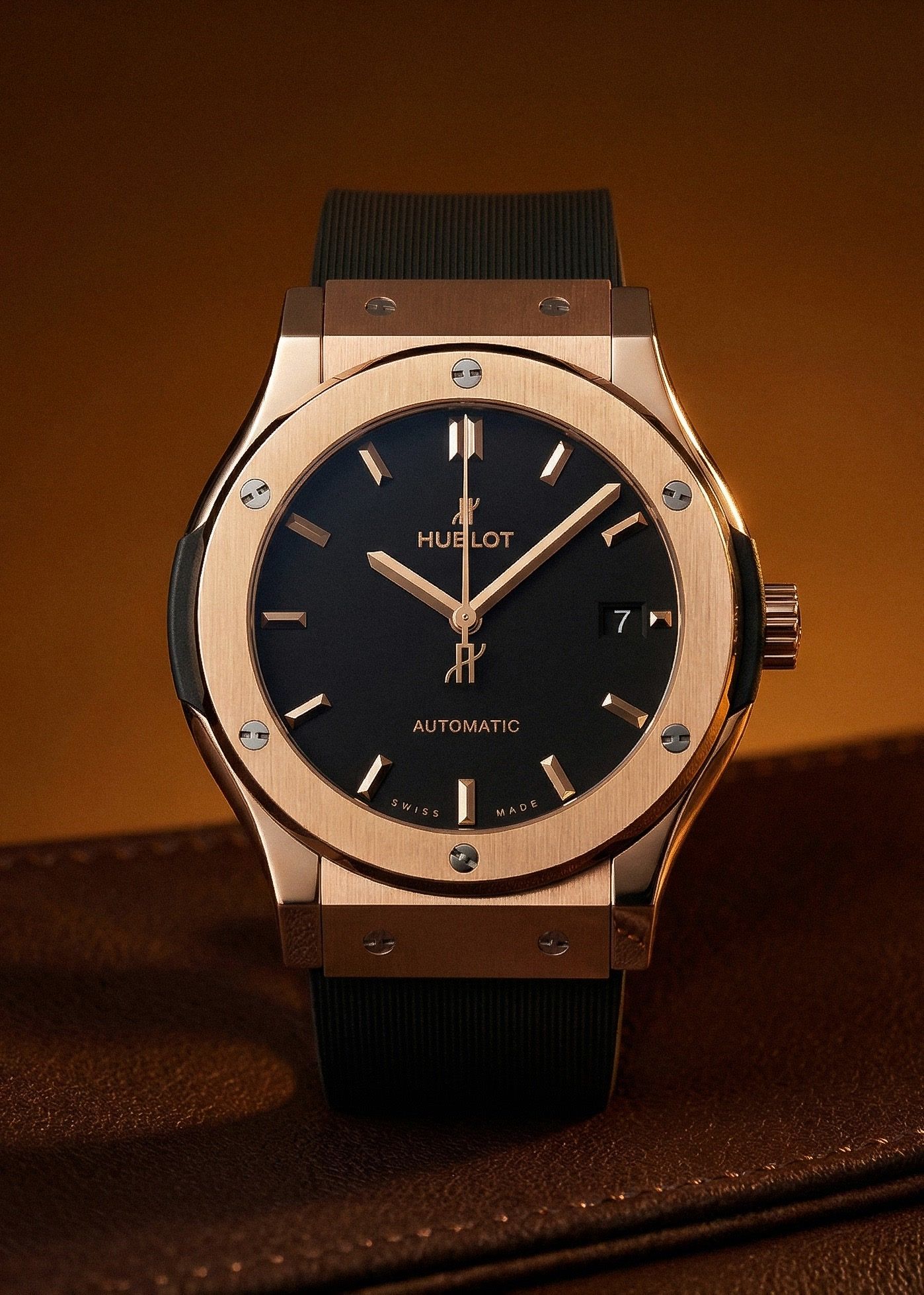 AI product photography of a Hublot rose-gold watch on brown leather under warm directional light — Chronos Studio.