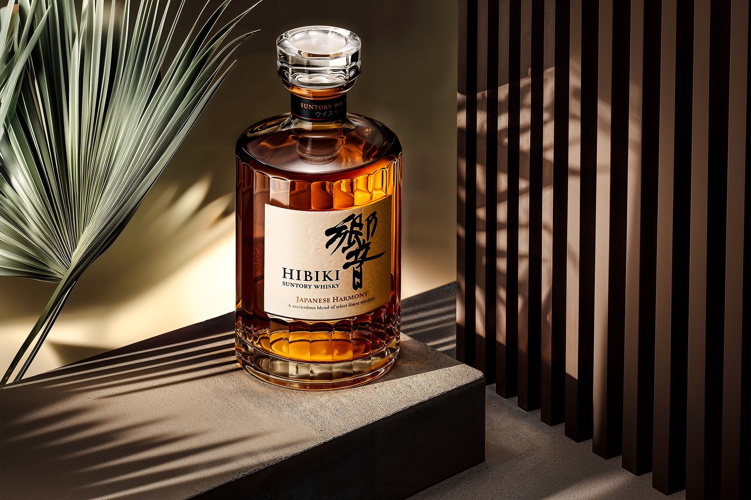 Hibiki Suntory whisky bottle on a stone plinth with palm shadows — case study by Chronos Studio.