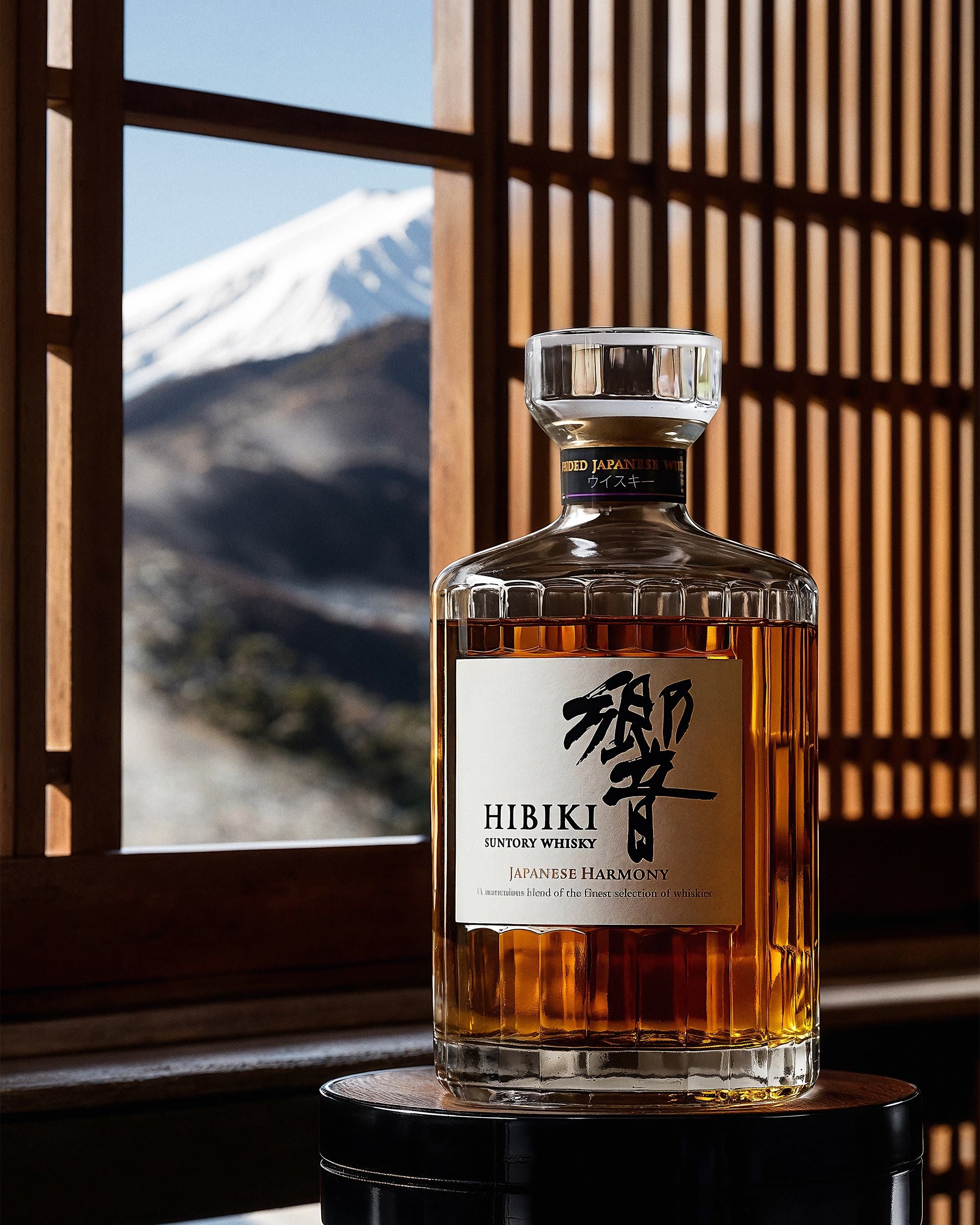 Hibiki bottle on a lacquered stool before a timber lattice window framing Mount Fuji — Chronos Studio.