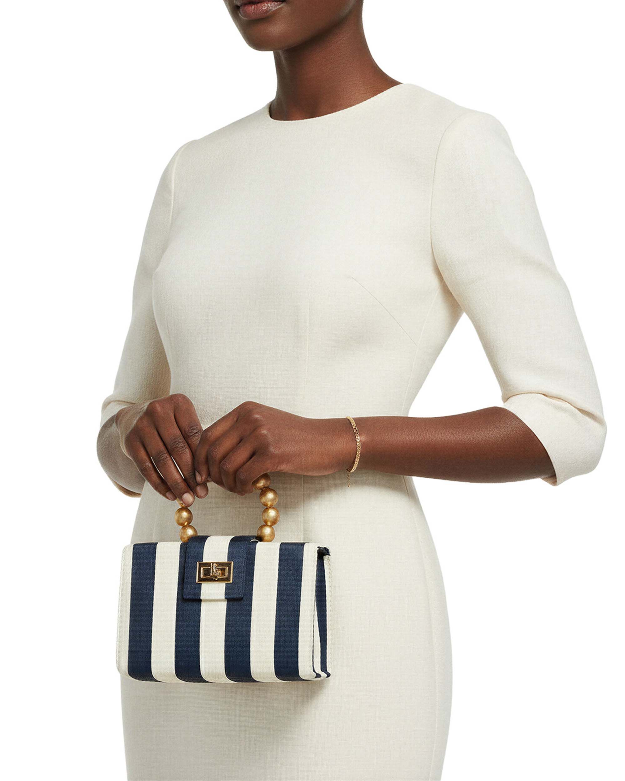 Model carrying a Soli & Sun handwoven bag in warm natural light — lifestyle retail photography by Chronos Studio.