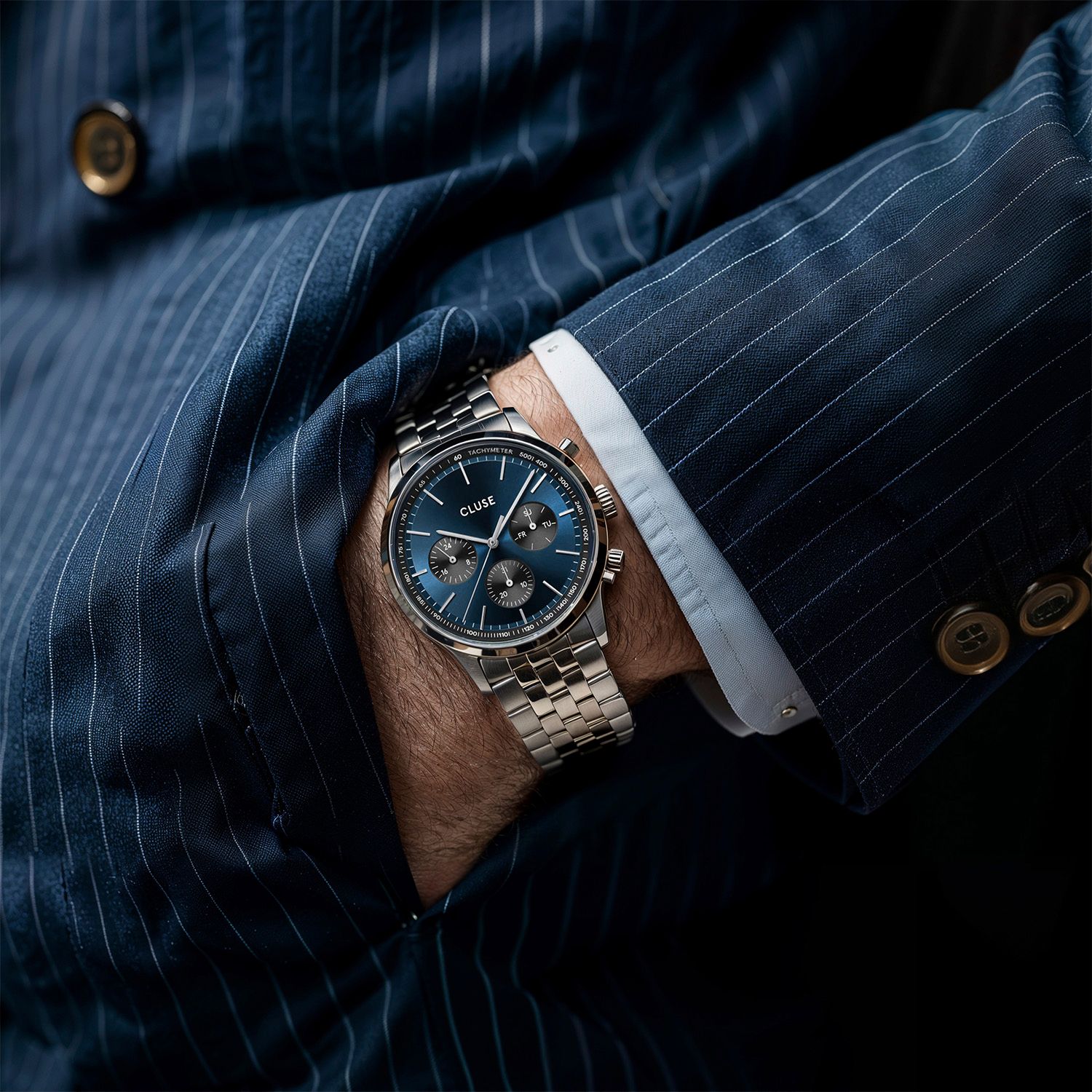 CLUSE chronograph square post with styled menswear detail — Chronos Studio.